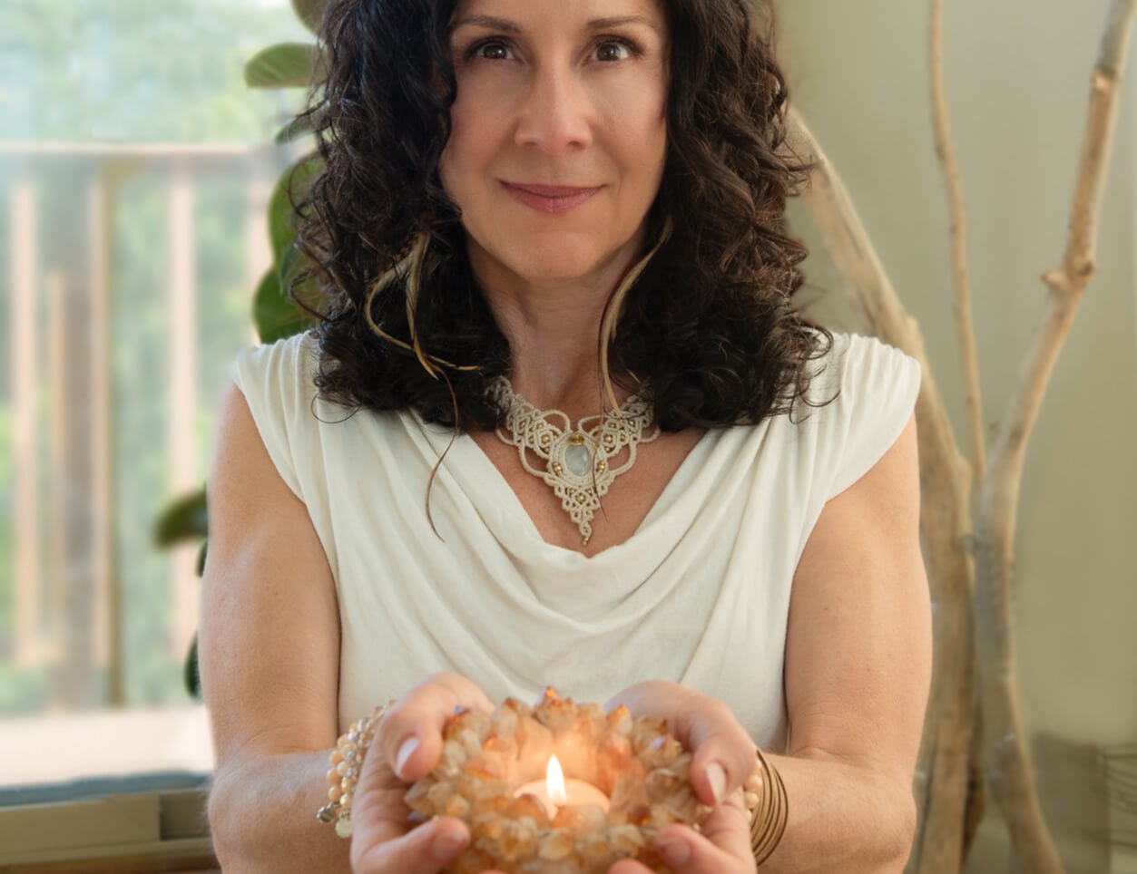 Angela Luna holding a candle in her hands with a smile<br />