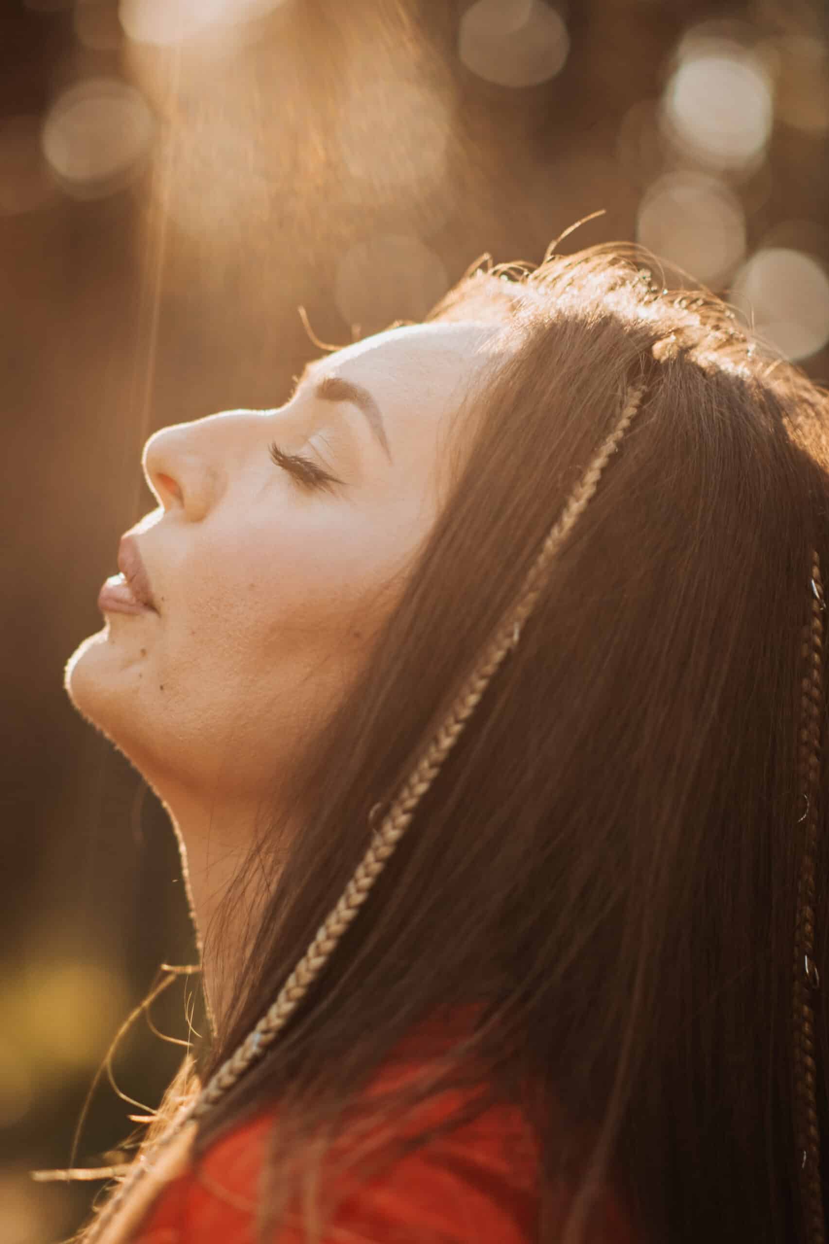 Outdoor portrait of beautiful smiling woman in sunlight. Smiling relaxing woman with boho hippie hair style. - trauma triggers